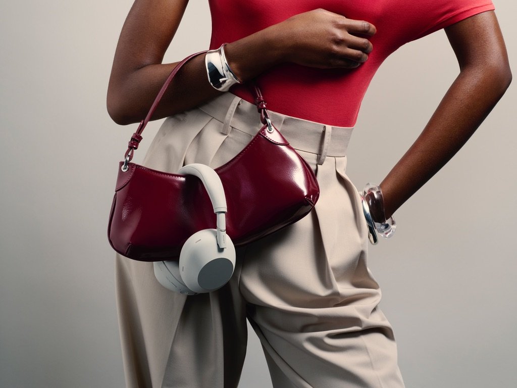 Auriculares Sony WH-1000XM6 en color blanco colgados de un bolso de mujer