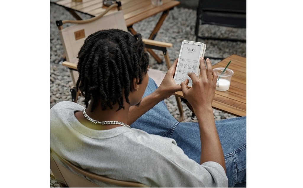 Persona usando el lector Boox Palma 2 al aire libre con interfaz de Android en pantalla