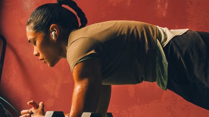 Mujer entrenando con AirPods Pro 3 de Apple, auriculares con ajuste seguro y resistencia al sudor